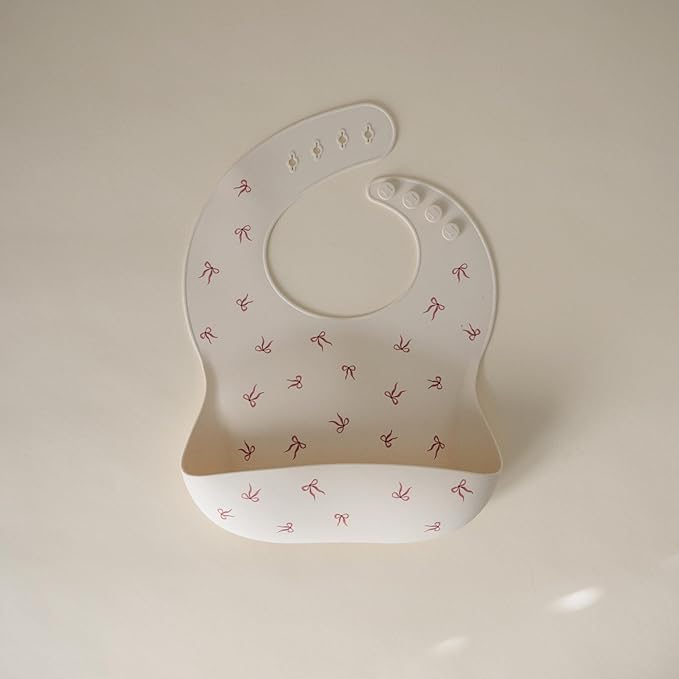 mushie Silicone Baby Bib | Adjustable Fit Waterproof Bibs (Bows)